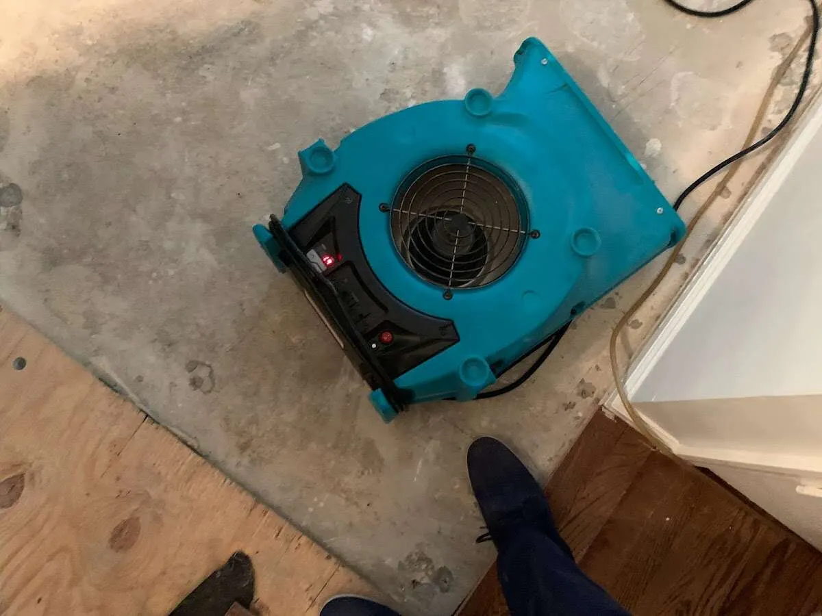 Air mover drying subfloor during Leak Detection & Repair in Woonsocket